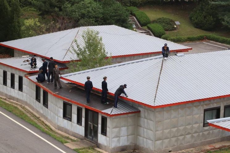 북한 작업인력들이 판문점 공동경비구역(JSA) 군사정전위원회 회의실 건물 지붕을 보수하고 있다. 유엔군사령부 트위터 갈무리