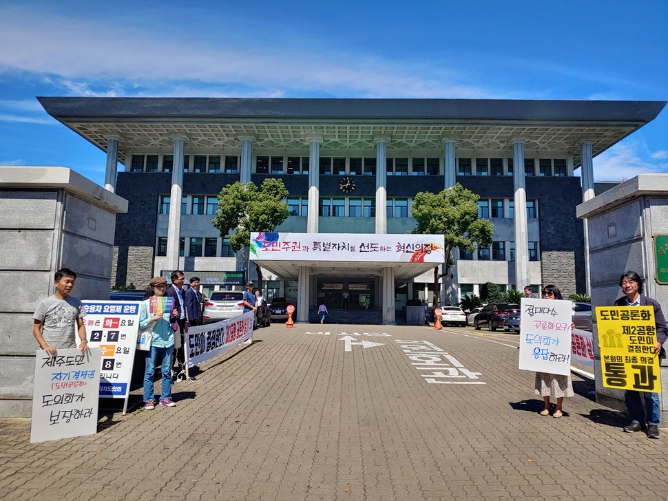 제주 제2공항 건설을 반대하는 시민사회단체가 24일 제주도의회 앞에서 ‘도민의 자기결정권 보장’ 등을 요구하며 손팻말 시위를 벌이고 있다.