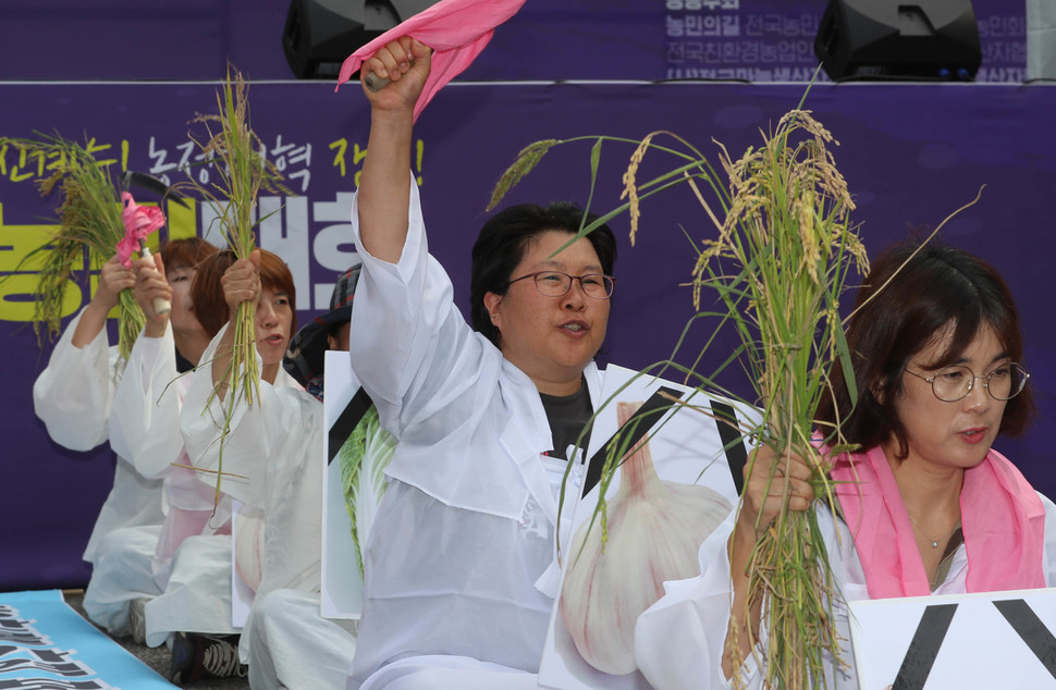 상복을 입은 채 볏단을 들어올리며 구호를 외치는 참가자들. 신소영 기자