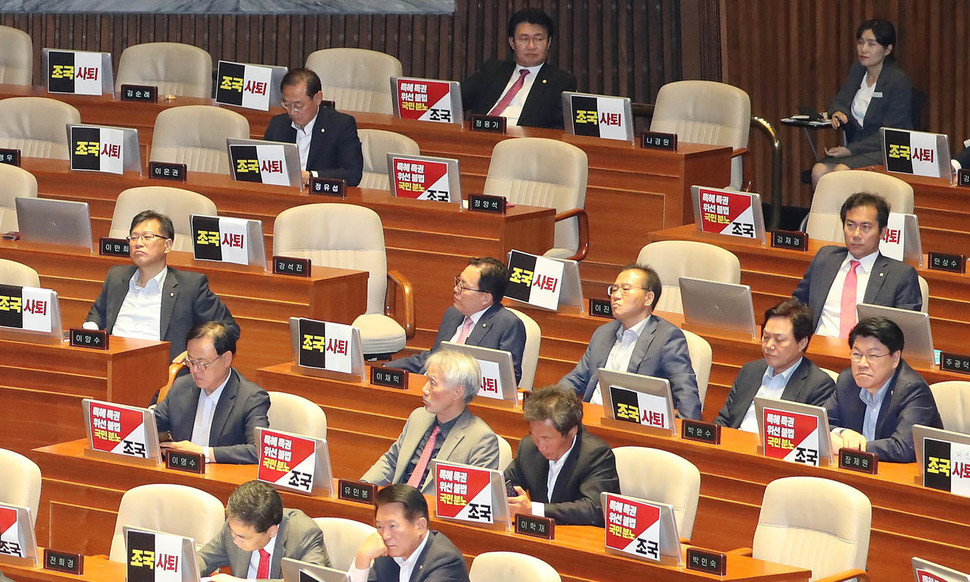 조국 법무부 장관이 26일 오후 국회 본회의장에서 열린 정치 분야 대정부질문에 참석하자 자유한국당 의원들이 ‘조국 사퇴'등이 적힌 손팻말을 붙이고 있다. 신소영 기자 viator@hani.co.kr