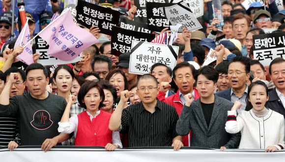 황교안 자유한국당 대표와 나경원 원내대표가 지난 21일 오후 서울 광화문 세종문화회관에서 열린 ‘문재인 정권 헌정 유린 중단과 위선자 조국 파면 촉구’ 대규모 장외집회를 마친 뒤 참가자들과 함께 청와대 방향으로 행진하고 있다. 연합뉴스