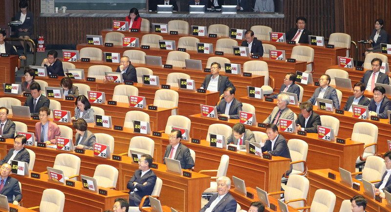 조국 법무부 장관이 26일 오후 국회 본회의장에서 열린 정치 분야 대정부질문에 참석하자 자유한국당 의원들이 '조국 사퇴'등이 적힌 손팻말을 붙이고 있다. 신소영 기자 viator@hani.co.kr