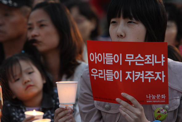 15일 저녁 서울 시청앞 광장에서 열린 미국산 쇠고기 수입 반대 촛불문화제에 참석한 시민이 “아이들을 지켜주자”라고 적힌 손팻말을 들고 있다. 신소영 기자 <A href="mailto:viator@hani.co.kr">viator@hani.co.kr</A>