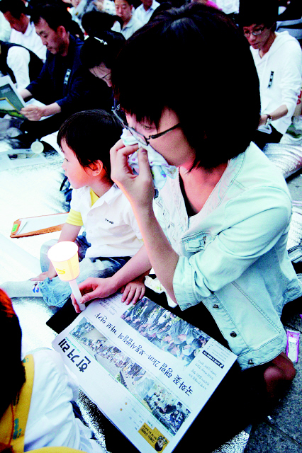 노무현 전 대통령을 추모하는 한 시민이 24일 저녁 서울 덕수궁 대한문 앞에서 25일치 <한겨레>를 읽으며 눈물을 닦고 있다. 
 김경호 기자 <A href="mailto:jijae@hani.co.kr">jijae@hani.co.kr</A>
