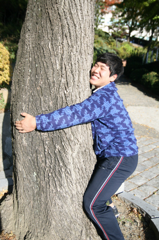 최성환이 20일 동아대 교정에서 아름드리나무를 뽑으려는 듯 힘을 쓰고 있다.