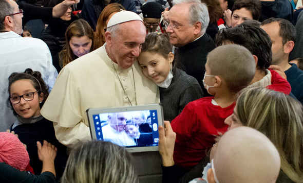 프란치스코 교황이 지난해 크리스마스를 앞두고 로마의 어린이병원을 찾아 여자어린이 환자와 사진을 찍고 있다. AFP