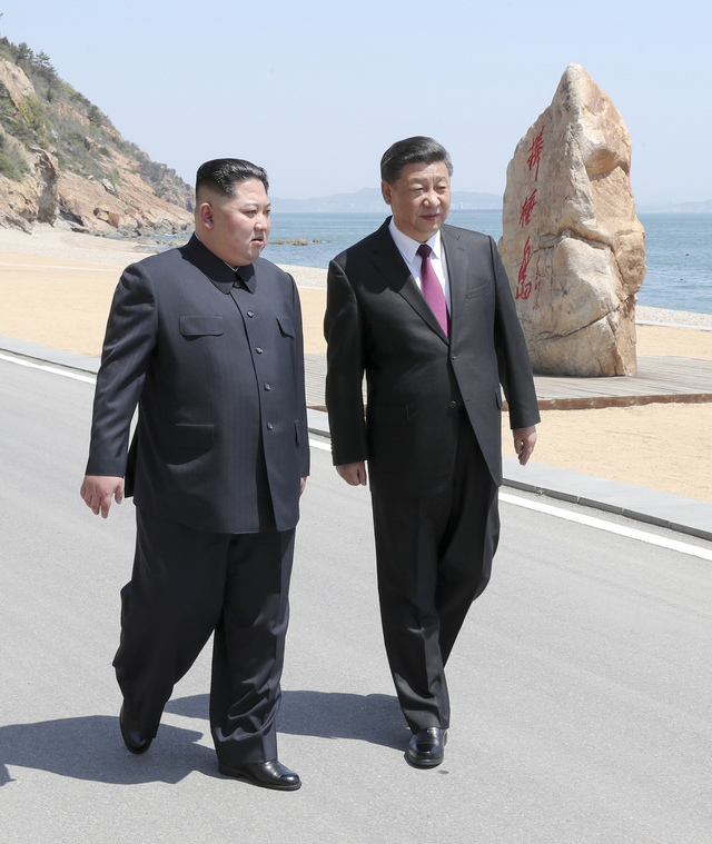 김정은 북한 국무위원장(왼쪽)과 시진핑 중국 국가주석이 8일 중국 랴오닝성 다롄에서 만나 방추이다오(봉추도) 해변을 걷고 있는 모습. 신화 연합뉴스