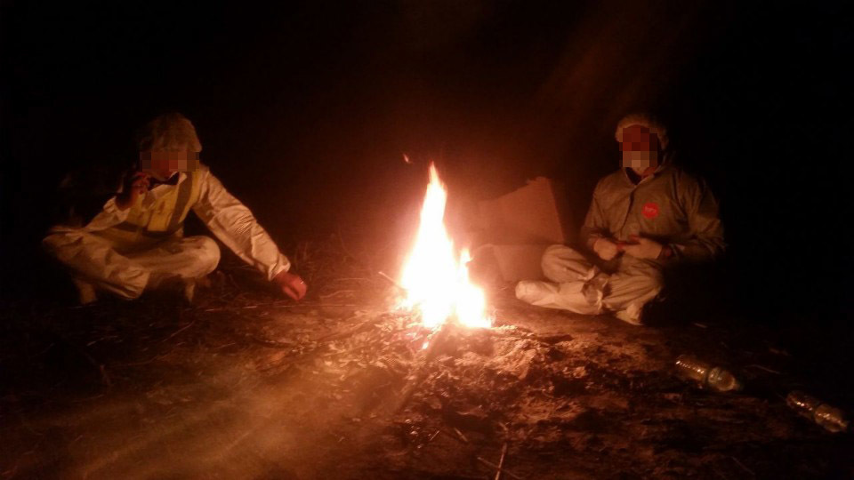 2016년 12월 경기도의 한 축산직 공무원이 산란계 농장에서 살처분 작업을 하던 중 방역복을 입고 불을 쬐며 쉬고 있다. 살처분 노동자 제공