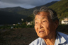 A deeply wrinkled grandmother sighs 